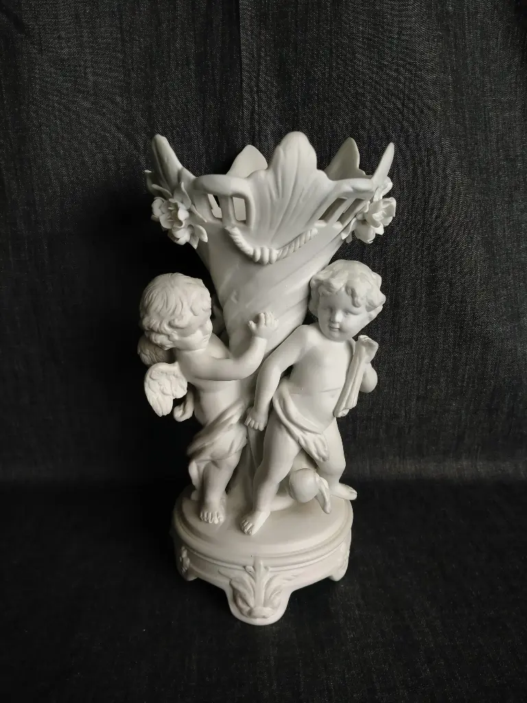 Centre de table en biscuit représentant deux putti autour d'une corne torsadée 