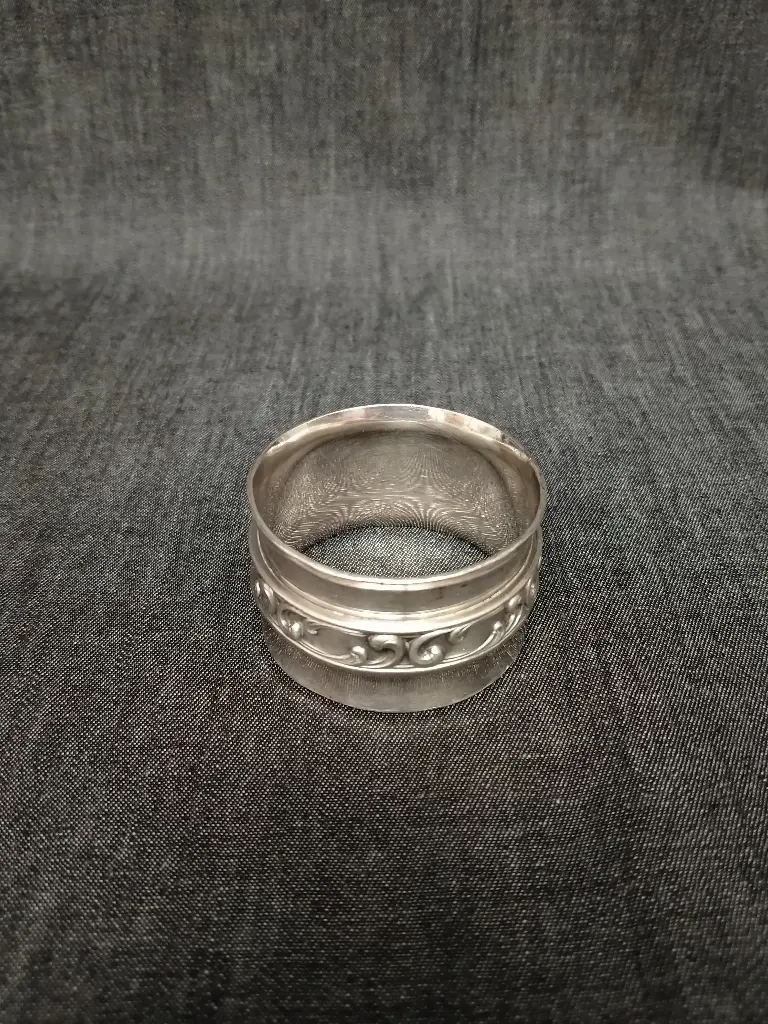 Rond de serviette en métal argenté décor de frise de rinceaux 